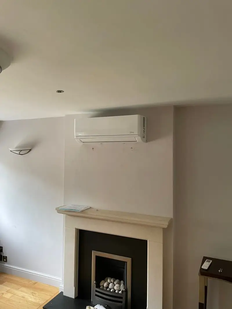 Air conditioning unit installed above a living room fireplace